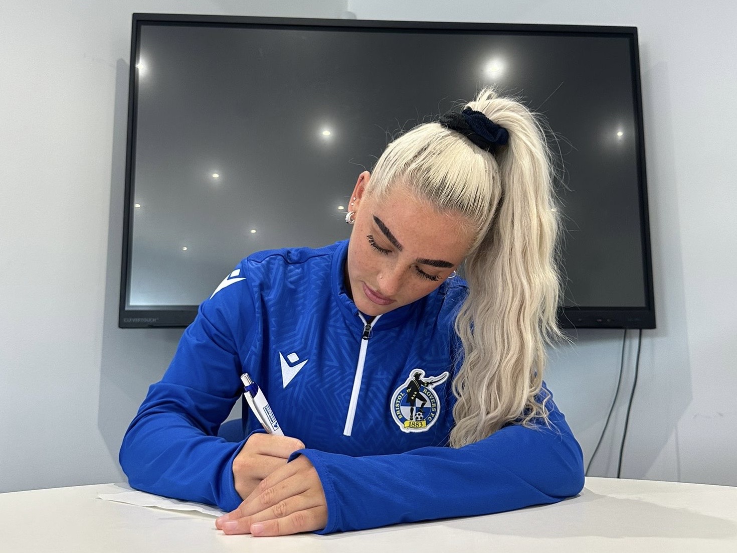 Daisy Ackerman signing a contract.
