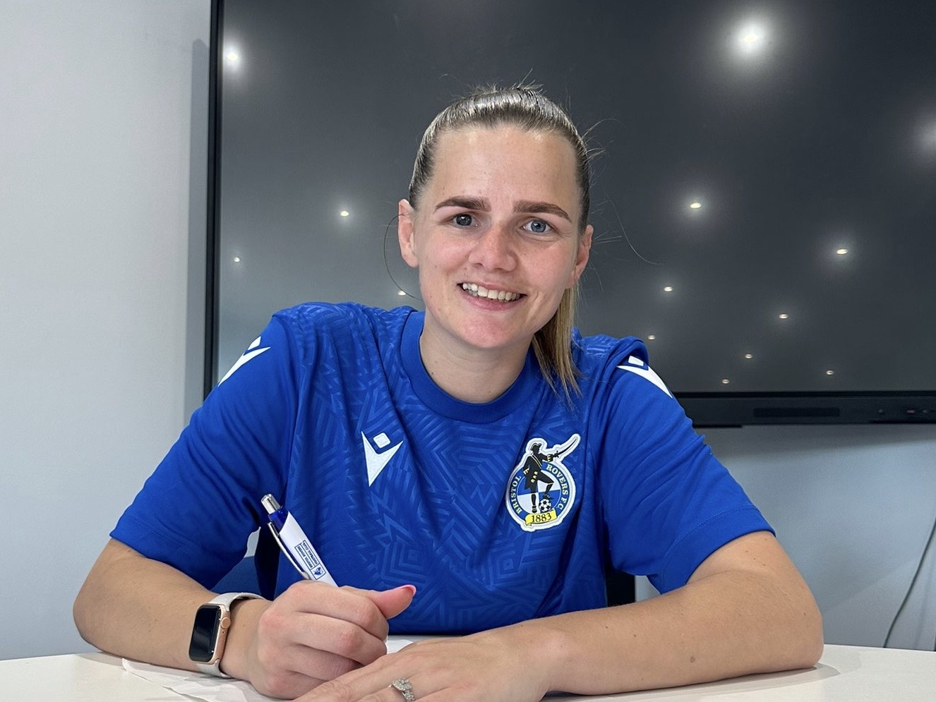 Rianne Bourne-Hallett signing a contract.