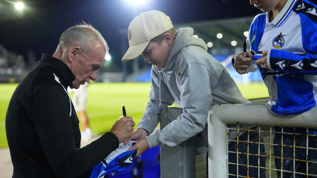 Manager Steve Evans signing young fans shirt