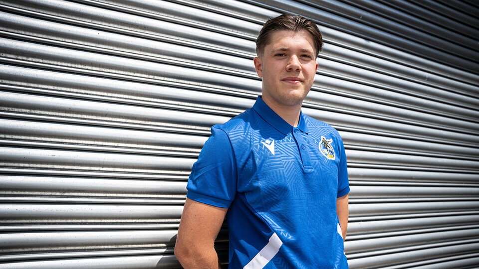 Charlie White leans against a gate