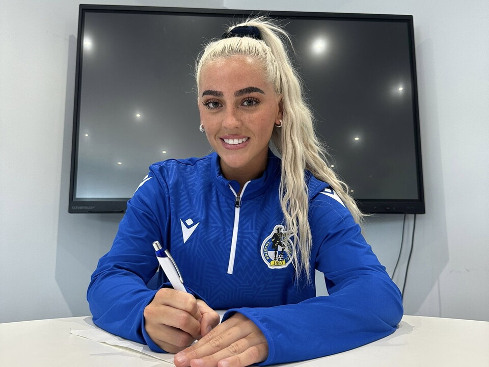 Daisy Ackerman signing a contract.