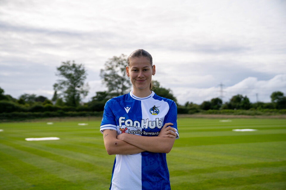Emily Arévalo in a Rovers shirt infront of a pitch.
