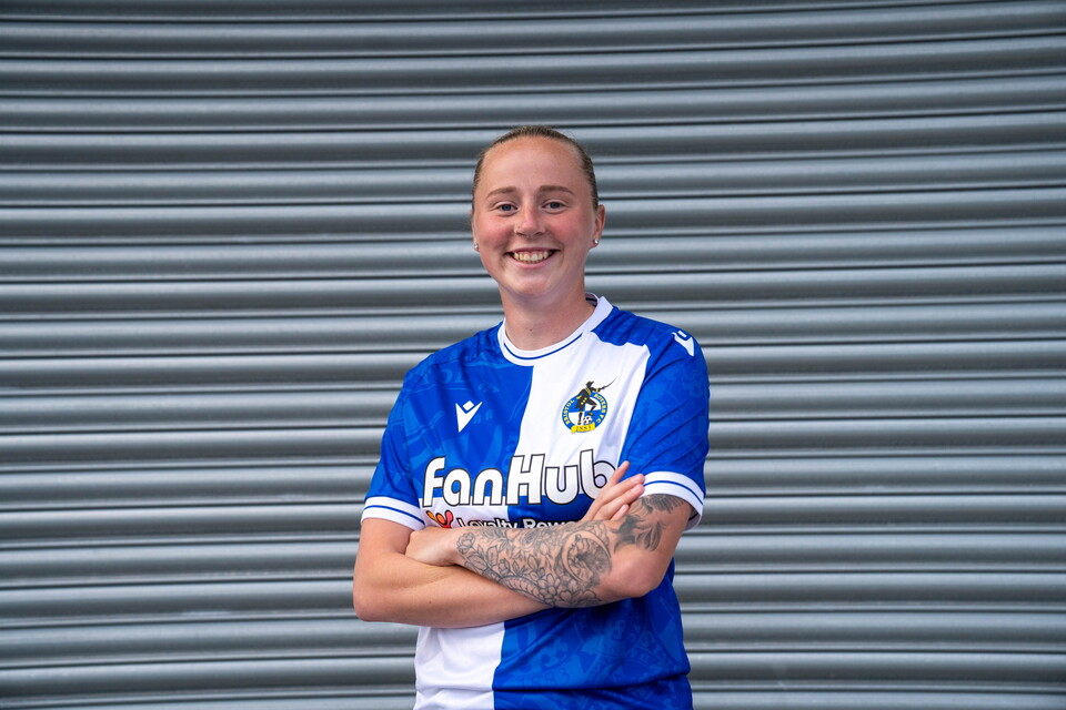 Erin Bloomfield in a Bristol Rovers Shirt in front of a shutter background.