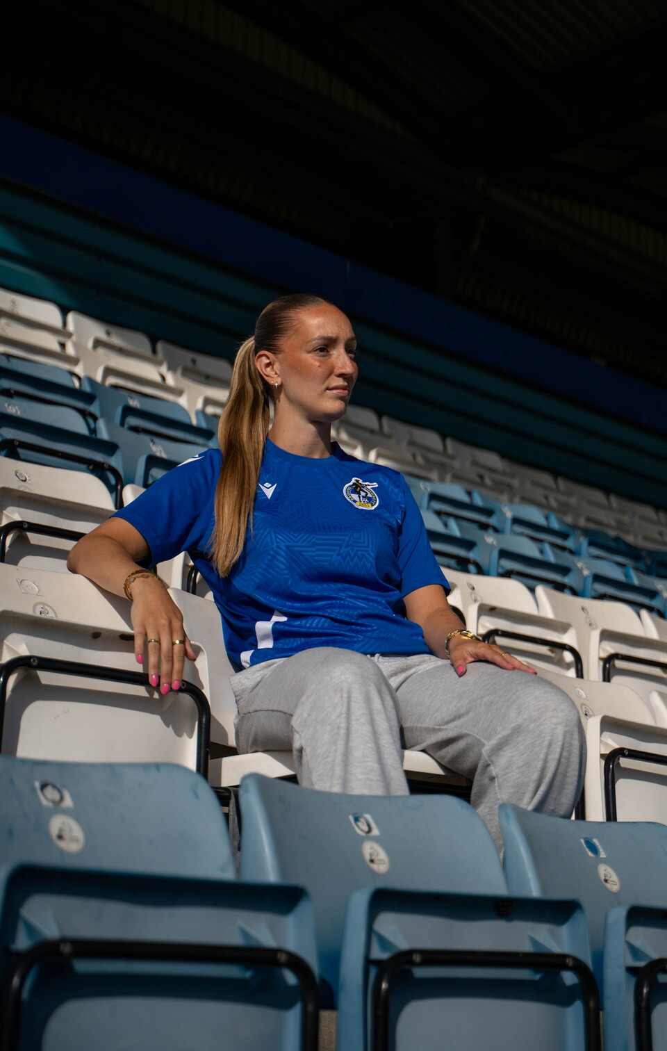 Chloe Gilroy in a Bristol Rovers shirt sitting in the stands.