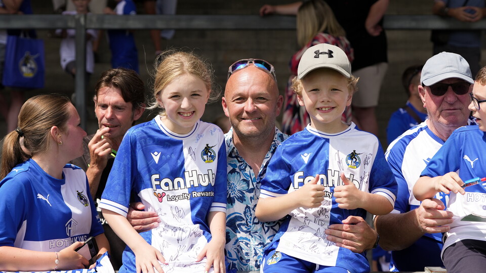 Three smiling Bristol Rovers fans in the Thatchers End
