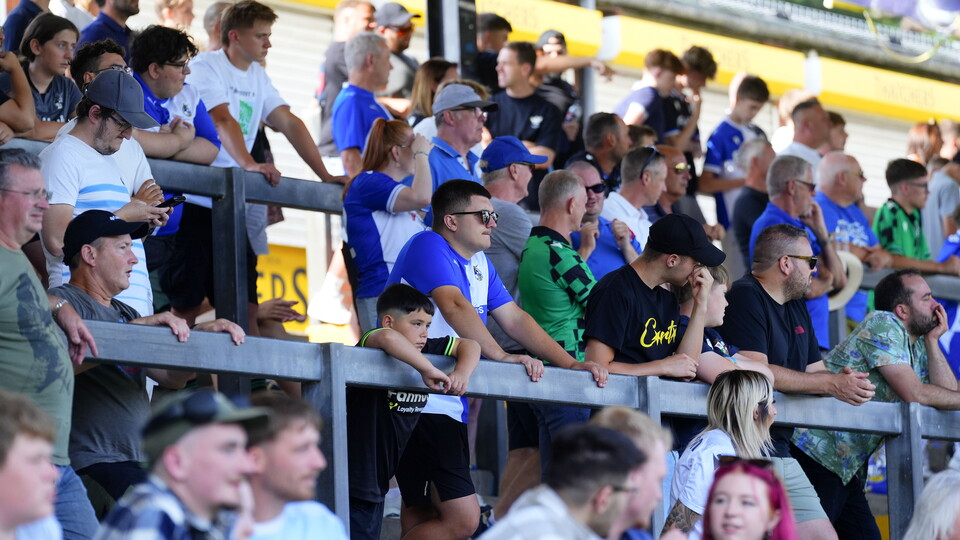 A crowd of Bristol Rovers fans looking at the pitch