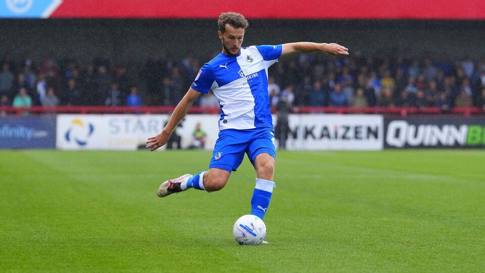 Tom James kicking the ball during his Crawley Town match