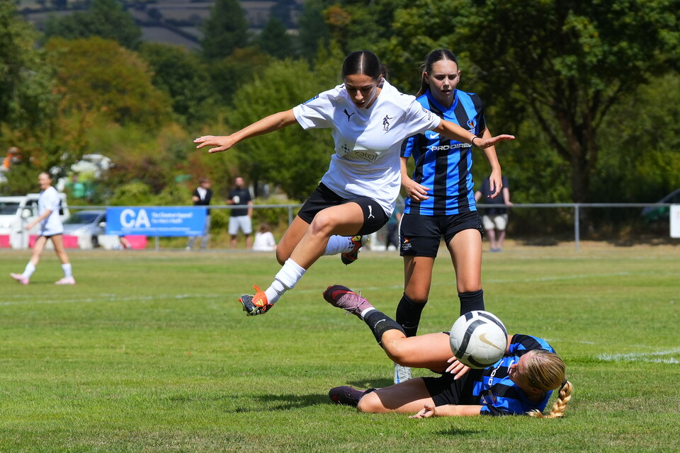 Helena Costa jumps over a defender.