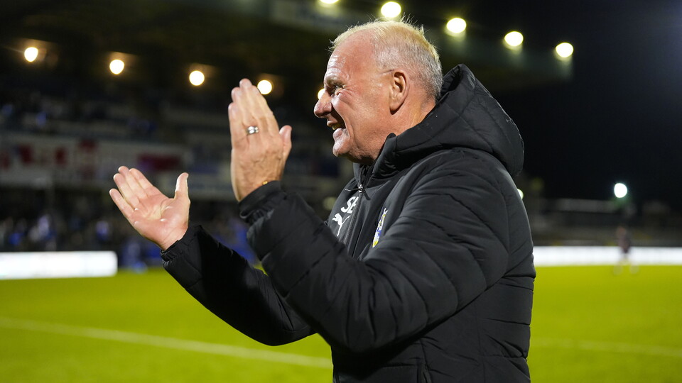 Steve Evans applauds his team and fans after the match