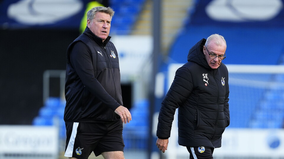 Steve Evans and Paul Raynor walking on the pitch before the game