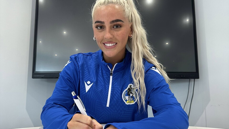 Daisy Ackerman signing a contract.