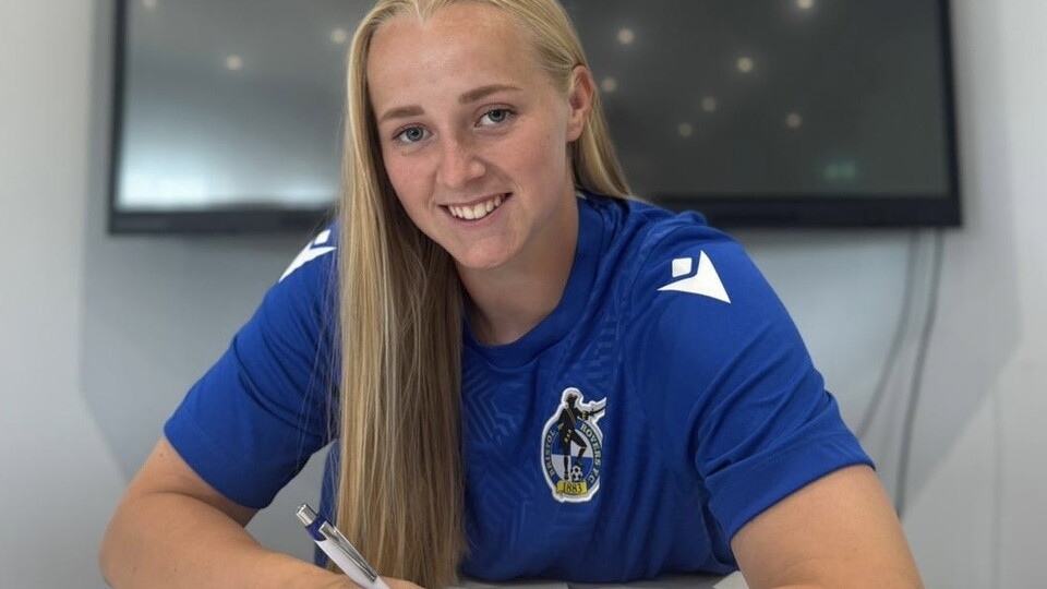 Meg Jarvis signing a contract.