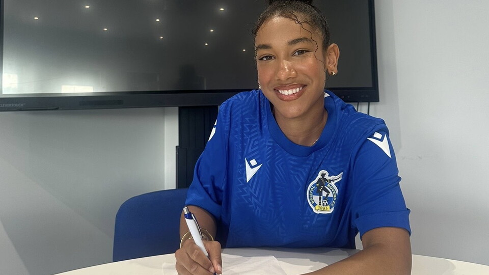 Layah Douglas signing a contract.