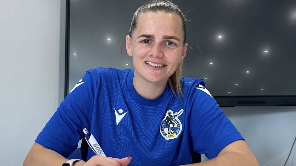 Rianne Bourne-Hallett signing a contract.