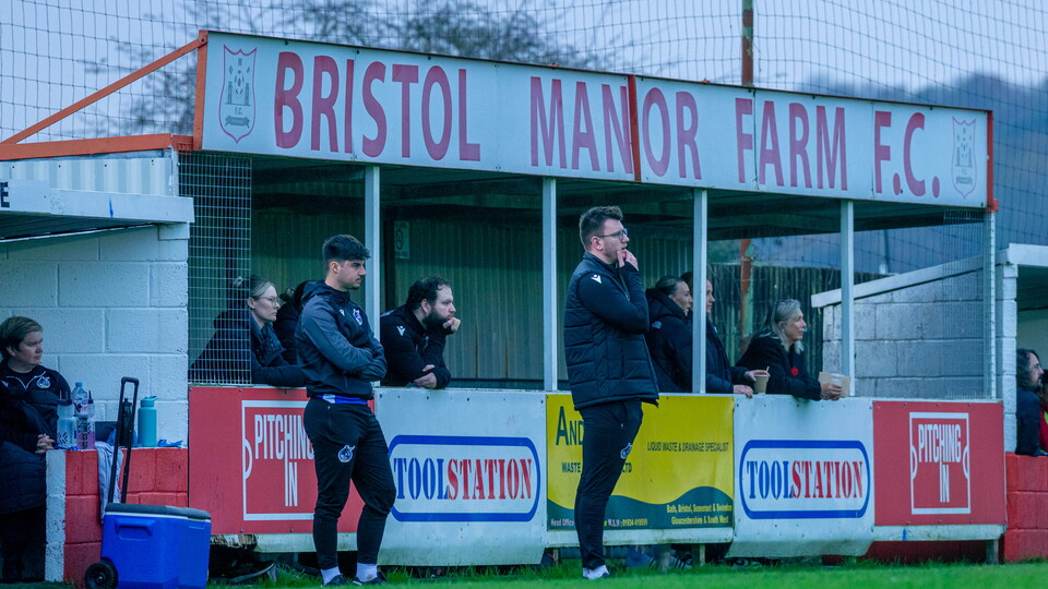 Manager Nathan Hallett-Young stands in his technical area mid-game at Bristol Manor Farm.